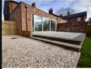 Brick single-storey extension with glazed doors, raised patio and gravel garden
