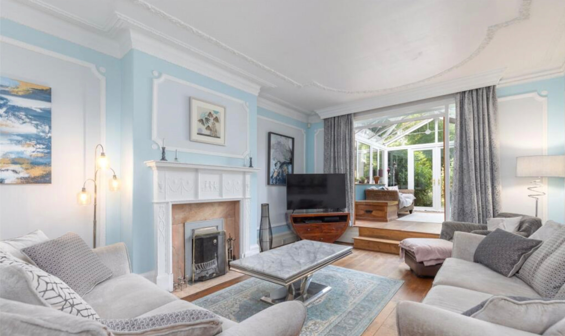 Living room with fireplace opening into the conservatory